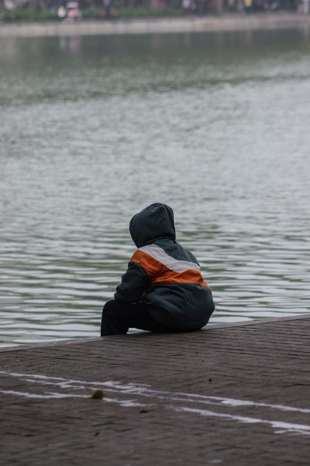 Young adult sat looking at river - Chiropractic Care for Young Adults